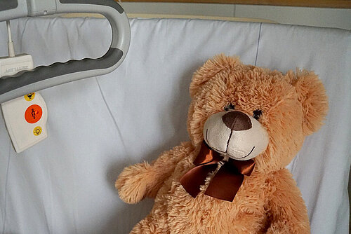 Teddybär liegt in einem Krankenbett