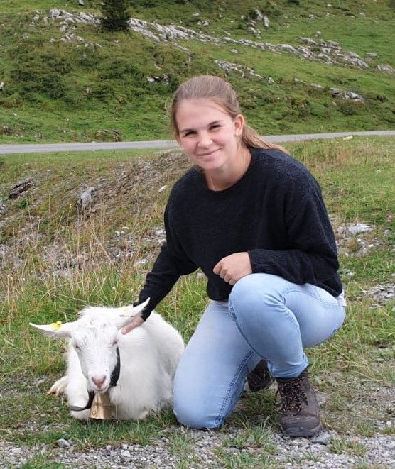 Portraitaufnahme von Tierärztin Nina Ossowski mit einem weißen Ziegenlamm