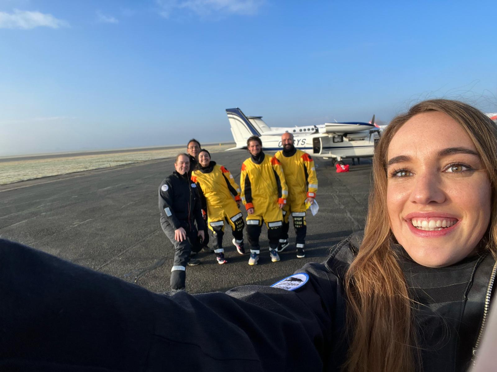 Survey team standing in front of aircraft