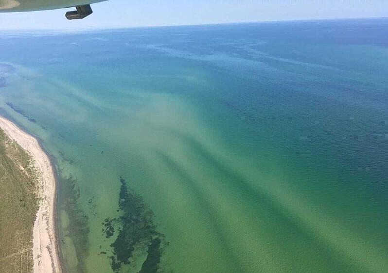Flugzeug über Wasser mit Blick auf die Küstenlinie