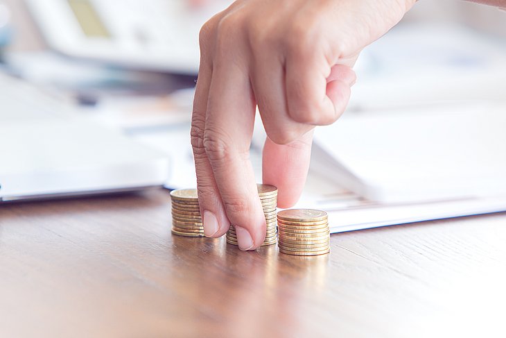 Eine Hand, Geldmünzen und Dokumente