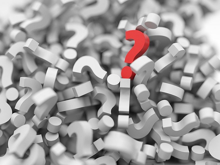 rotes Fragezeichen auf einem Haufen von weißen Fragezeichen