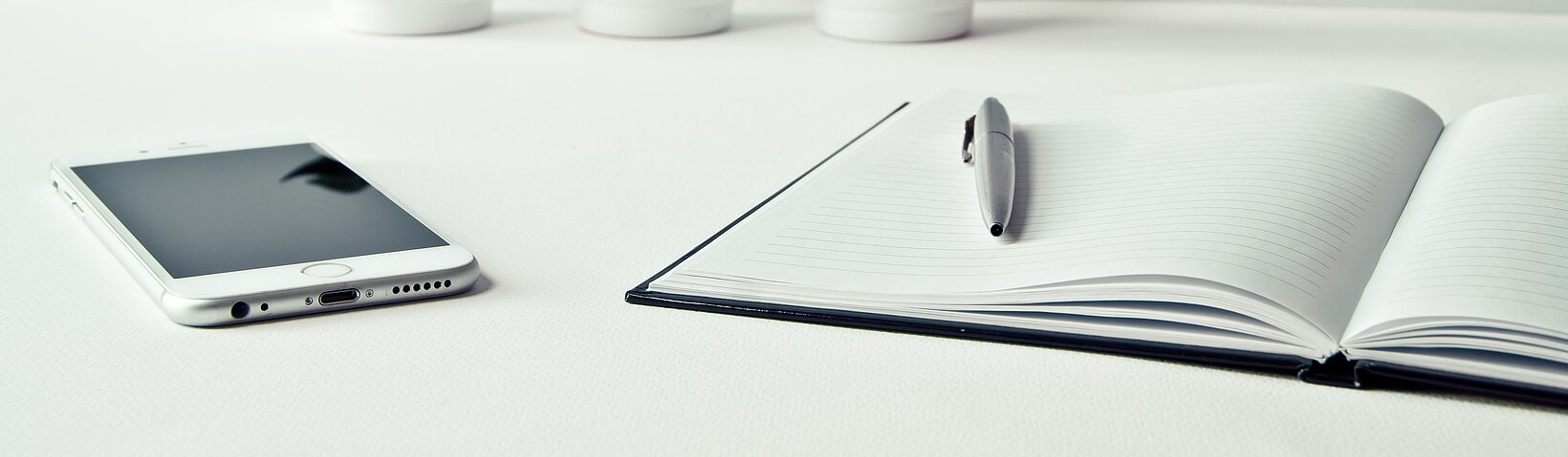 Tablet PC und Buch mit Stift auf weißem Tisch 