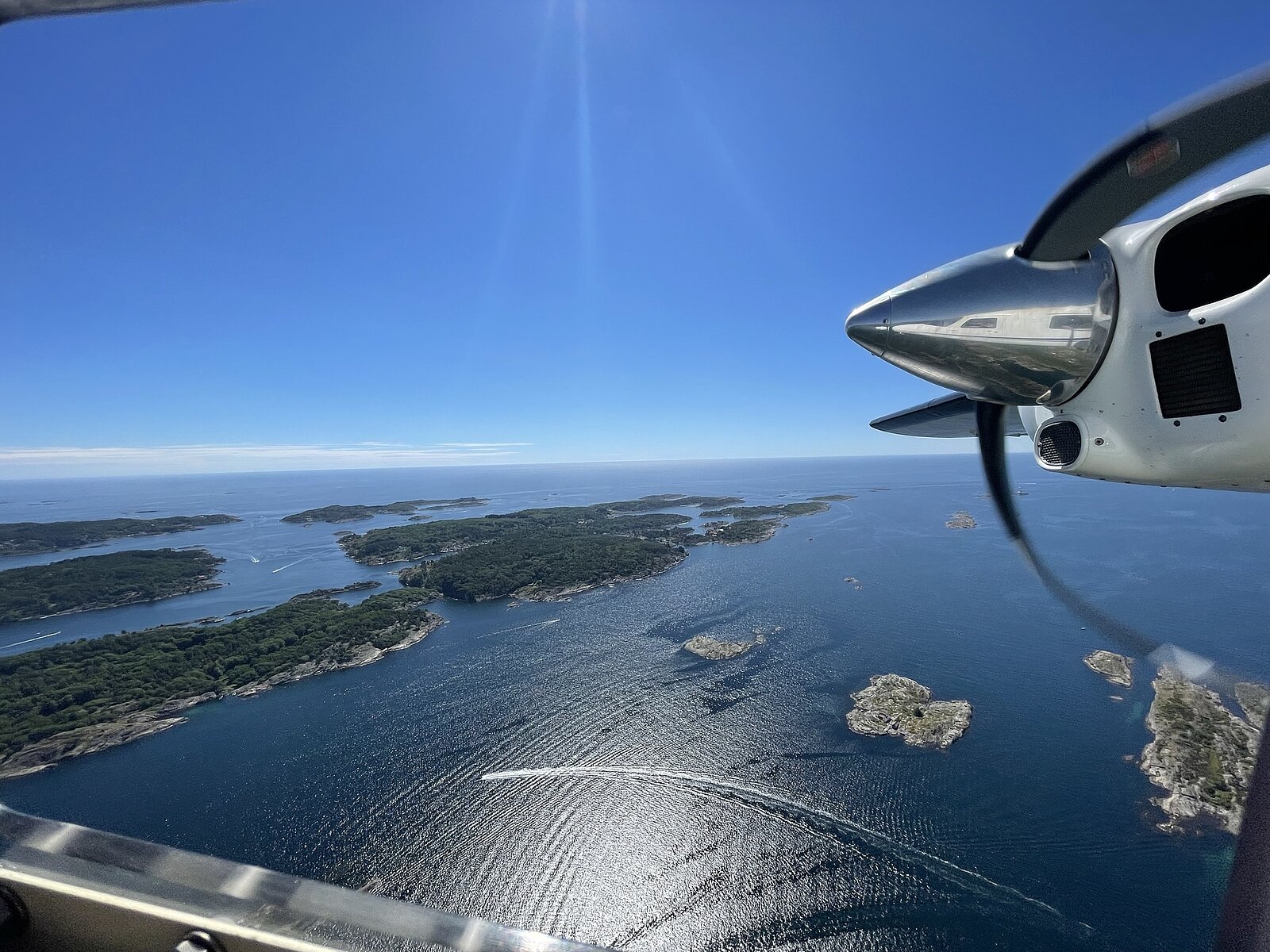 Blick aus einem Flugzeug das über Inseln fliegt
