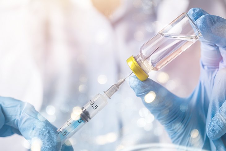 Person zieht Spritze auf