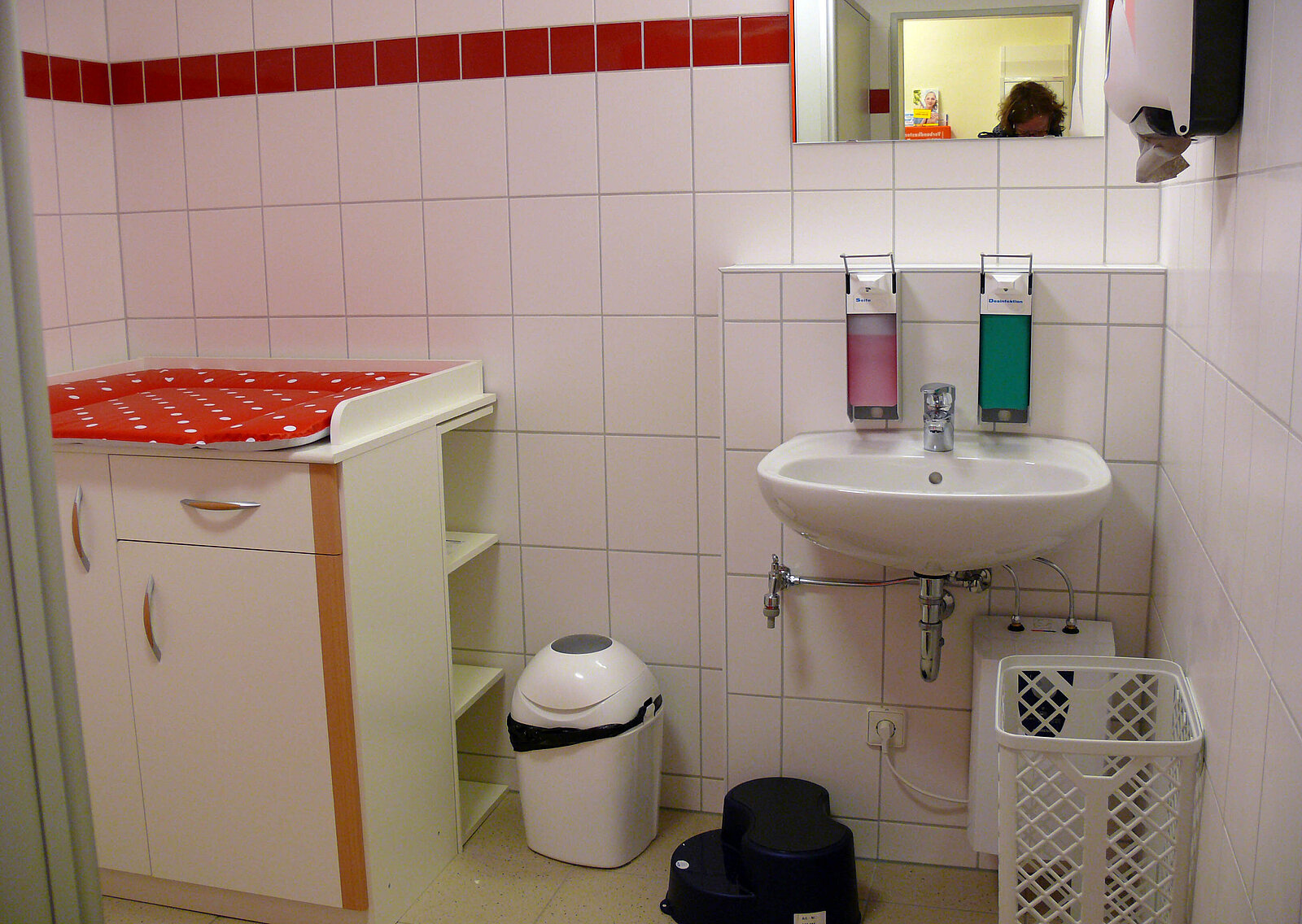 Badezimmer mit Wickeltisch und Waschbecken