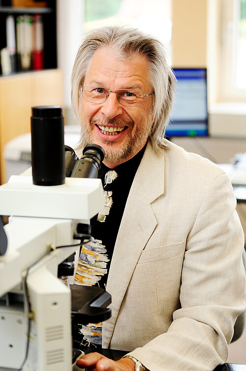 Professor Dr. Wolfgang Baumgärtner an einem Mikroskop
