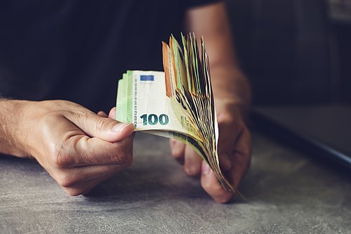 Zwei Hände halten ein Bündel Euro-Geldscheine