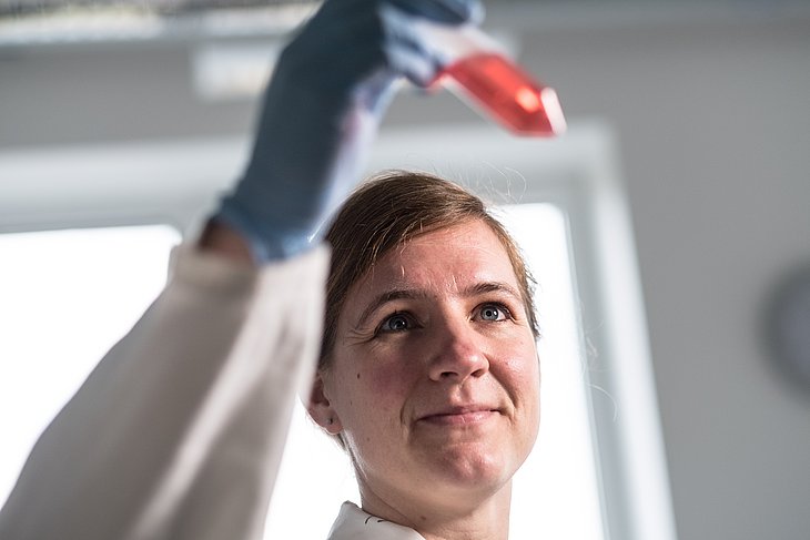 Dr. Imke Steffen betrachtet ein Zentrifugenröhrchen.