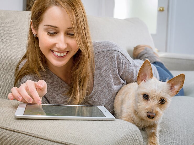 [Translate to English:] Studentin mit Hund mit Tablet