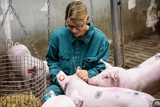 Photo: Prof. Nicole Kemper in a barn with pigs