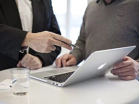 High table with laptop and two people