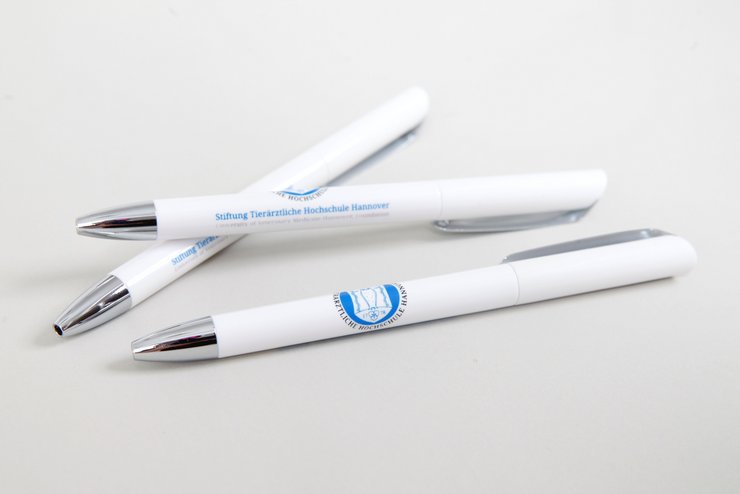 drei weiße Kugelschreiber mit TiHo-Logo