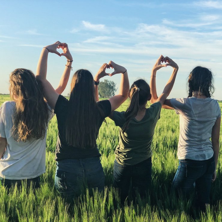 Vier Mädchen stehen auf einem Feld