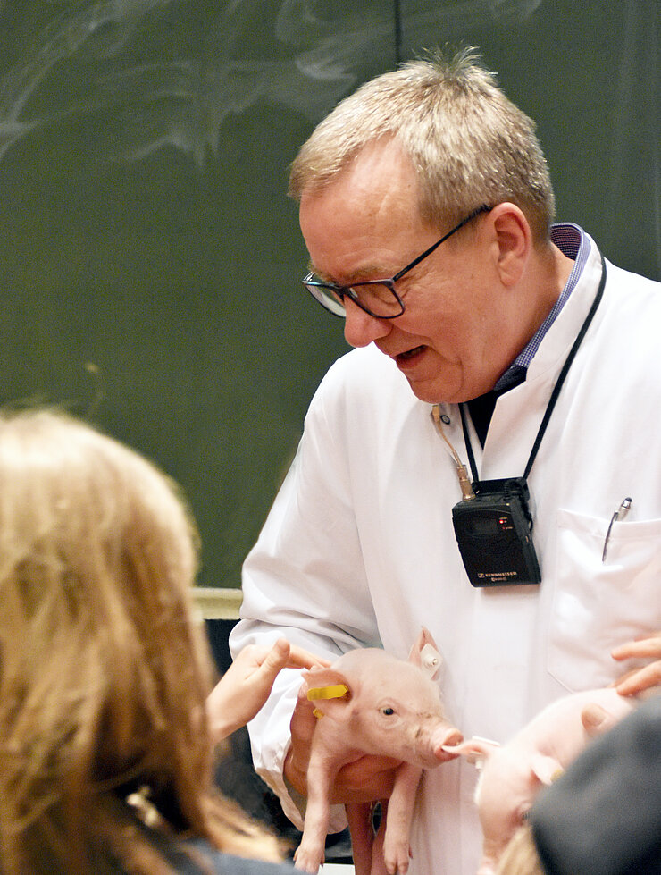 Professor Waldmann mit Ferkel im Arm